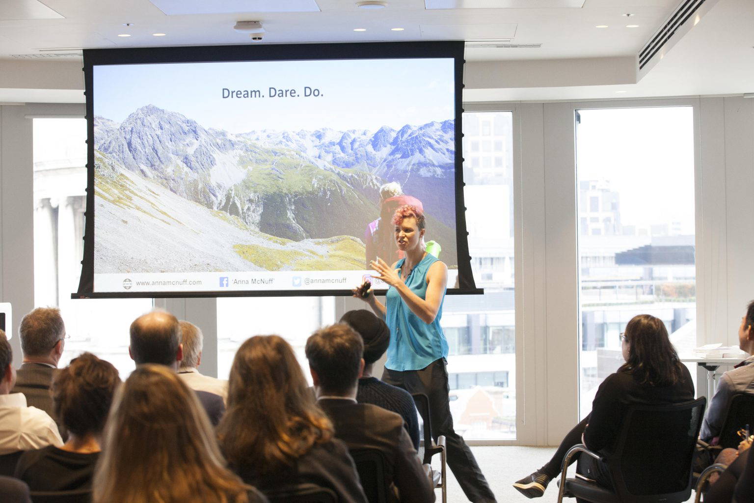 Anna McNuff giving a corporate keynote talk with a Dream. Dare. Do. slide