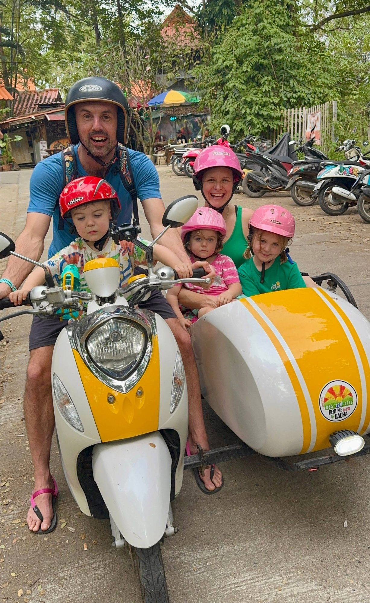 Anna McNuff, Jamie McDonald and their three children on a motorbike with a sidecar